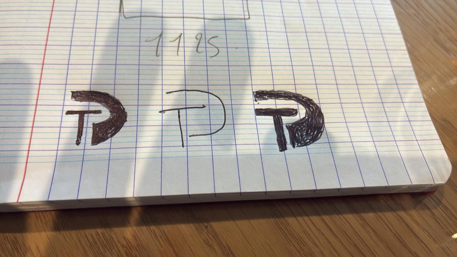 Croquis du monogramme DT dessinés par les clients sur papier quadrillé